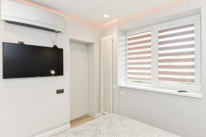 a living room with a flat screen tv on the wall at Apartamentai centre pas Lina in Nida