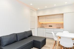 a living room with a couch and a table at Apartamentai centre pas Lina in Nida +3 photos