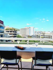 a table and chairs on a balcony with a view of a city at Downtown, penthouse apartment with great view, Pagkrati in Athens
