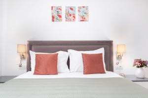 um quarto com uma cama com almofadas laranja e branca em Charlotte Piata Unirii - Free Parking 2bedrooms Apartment em Oradea