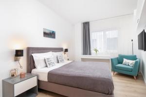 um quarto com uma cama e uma cadeira azul em Charlotte Piata Unirii - Free Parking 2bedrooms Apartment em Oradea