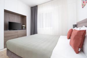 a bedroom with a bed with a tv on it at Josephine Apartment - Free Private Parking 2bedrooms in Oradea +42 photos