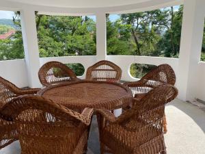 - une table et des chaises en osier sur une terrasse couverte dans l'établissement Casa Silvia, à Eşelniţa