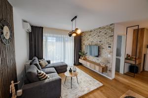 a living room with a couch and a brick wall at ARA Apart Hotel Brasov in Braşov