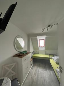 Cette petite chambre comprend un lit et un miroir. dans l'établissement Pension Eckert, à Zwenkau