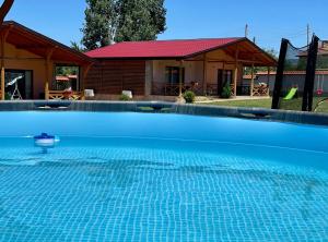 a large blue swimming pool in front of a house at Къщи за гости “Планински Рай” Mountain Paradise in Resilovo