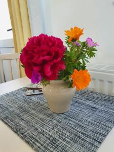 un vaso pieno di fiori seduto su un tavolo di Boots Cottage a Bude