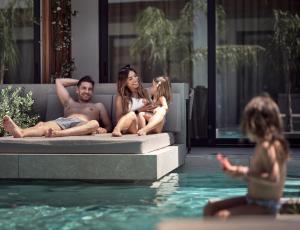 a group of people sitting next to a swimming pool at Contessina Hotel in Tsilivi