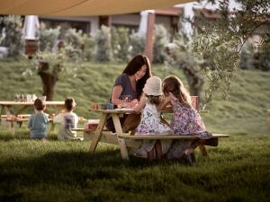 a woman and two little girls sitting at a picnic table at Contessina Hotel in Tsilivi