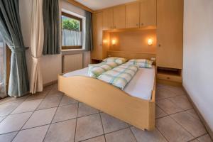 a bedroom with a bed with a wooden headboard at App Sonne Nr 18 in Lutago