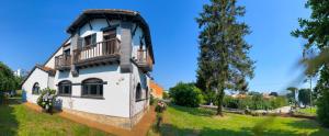 Casa blanca con balcón en la parte superior. en Casa Rural Villa Luisa en poo de Llanes