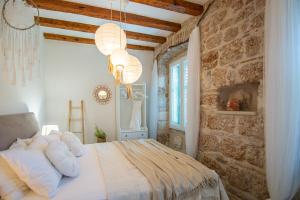 a bedroom with a bed and a stone wall at Apartments Mali Raj Komiza in Komiža