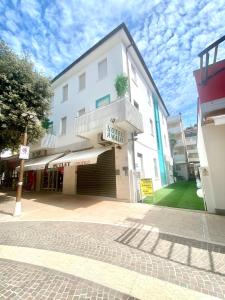 un bâtiment blanc avec un panneau devant lui dans l'établissement Hotel Amalfi & Dépendance, à Lignano Sabbiadoro