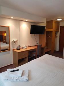 Habitación de hotel con cama y escritorio con TV. en V Lodge Manchester en Mánchester