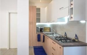 uma cozinha com um lavatório e um fogão em Cozy Home In Budoni With Kitchenette em Budoni