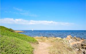 a dirt path next to the ocean with a sail boat at 1 Bedroom Cozy Home In Budoni in Budoni
