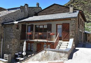 een stenen huis met een veranda en een balkon bij Maison Olivotto in Valcebollère