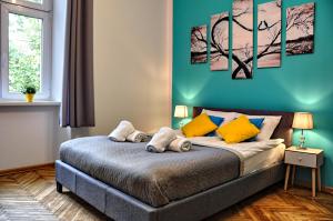 a bedroom with a bed with a blue wall at Wiślna 4 by Homeprime in Krakow