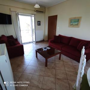 a living room with a red couch and a coffee table at ARETI 3 in Petalidi