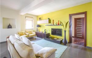 sala de estar amarilla con sofá y TV en Nice Apartment In Reggio Calabria With Wifi, en Reggio Calabria