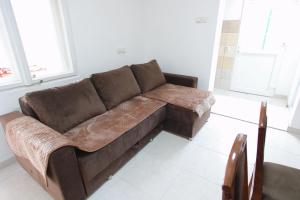 a brown couch sitting in a living room at Apartman Rakić in Soko Banja