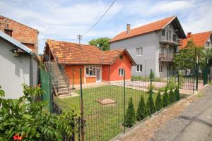 a fence in front of a house with a yard at Apartman Rakić in Soko Banja