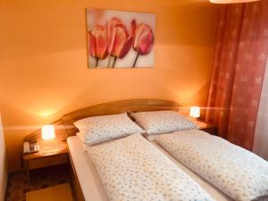 łóżko z 2 poduszkami i zdjęciem kwiatów w obiekcie Braunegger-Hof Gasthof Mayer w mieście Braunegg +9 zdjęć