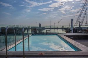 a large swimming pool with a view of a harbor at Harbour Bridge 1 Bedroom in Waterfront Precinct in Cape Town