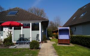a house with a red umbrella and a patio at Ferienhaus große Krabbe in Neuharlingersiel