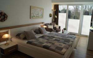 a bedroom with a large bed in a room with windows at Ferienhaus große Krabbe in Neuharlingersiel