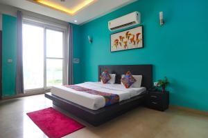 um quarto com uma cama e uma parede azul em FabExpress King's One em Noida