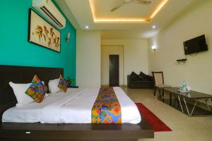um quarto com uma cama grande e uma sala de estar em FabExpress King's One em Noida