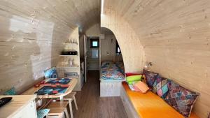 una casetta minuscola con una grande stanza con panchine e tavoli di Tiny House Carlos a Stuer