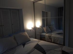 a bedroom with a large mirror and a bed at Budva center apartmant in Budva