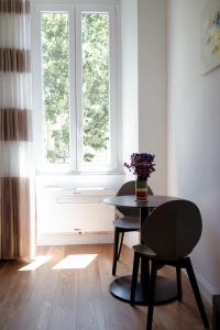 a table and chairs in a room with a window at Beatrix House in Rome