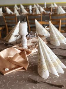 Braunegger-Hof Gasthof Mayer في Braunegg: طاولة عليها مناديل بيضاء وكؤوس للنبيذ
