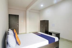 um quarto com uma cama e uma secretária. em Raison Hotel em Jamshedpur