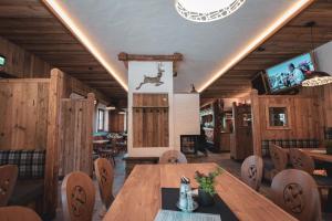 una sala da pranzo con tavolo, sedie e TV di d'Genussalm by Alpine Genusswelten a Haus im Ennstal