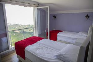 a bedroom with two beds and a large window at Kartal Gözü Konaklama tesisi in Rize