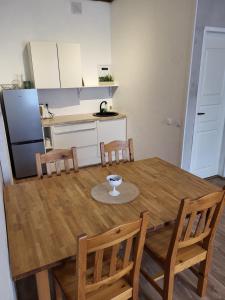 a kitchen with a wooden table with chairs and a refrigerator at Old Town Apartment nr 2 in Valga