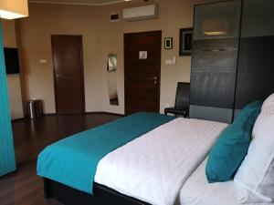 1 dormitorio con 1 cama grande con manta azul en Parton Hotel & Bowling en Tiszakécske