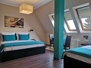 a bedroom with two beds and two windows at Parton Hotel & Bowling in Tiszakécske