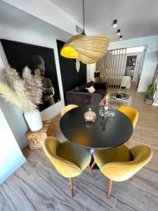 a living room with a black table and yellow chairs at Ágata 10-4E in Alicante