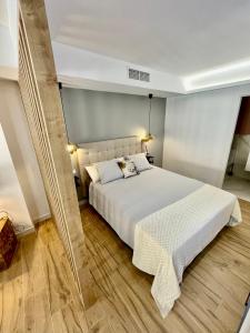 Schlafzimmer mit einem großen weißen Bett und Holzböden in der Unterkunft Ágata 10-4E in Alicante