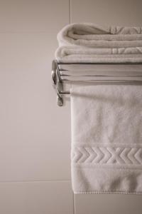 a stack of towels on a towel rack in a bathroom at Hotel Restaurante Rúas in Pontevedra