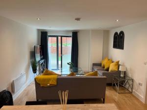 sala de estar con sofá y almohadas amarillas en Lovely 2 Bed apartment in Leeds centre (Netflix), en Leeds