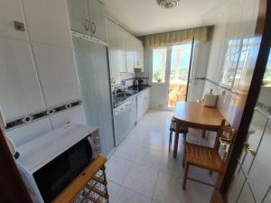 a kitchen with white cabinets and a table and a sink at Atauri in Haro