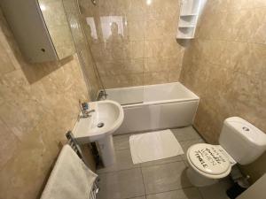 a bathroom with a sink and a toilet and a tub at Vetrelax Basildon Newly refurbished 3bed House in Basildon