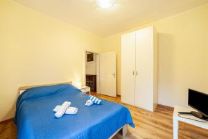 a bedroom with a blue bed and a television at Residence Hubertus Apartment 4 in Merano