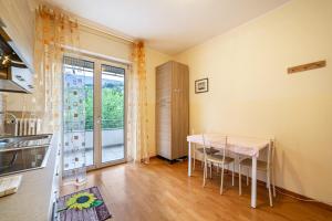 ein Esszimmer mit einem Tisch und einem Balkon in der Unterkunft Residence Hubertus Apartment 4 in Meran